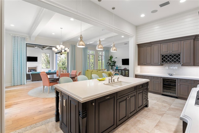 10143 Mattraw Pl, Golden Oak, FL 32836 - kitchen featuring wine cooler, open floor plan, ornamental molding, a center island with sink, and light countertops