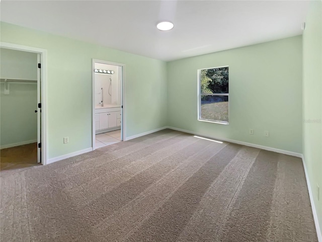 1877 Courtland Blvd, Deltona, FL 32738 - unfurnished bedroom featuring carpet flooring, a spacious closet, connected bathroom, and a closet