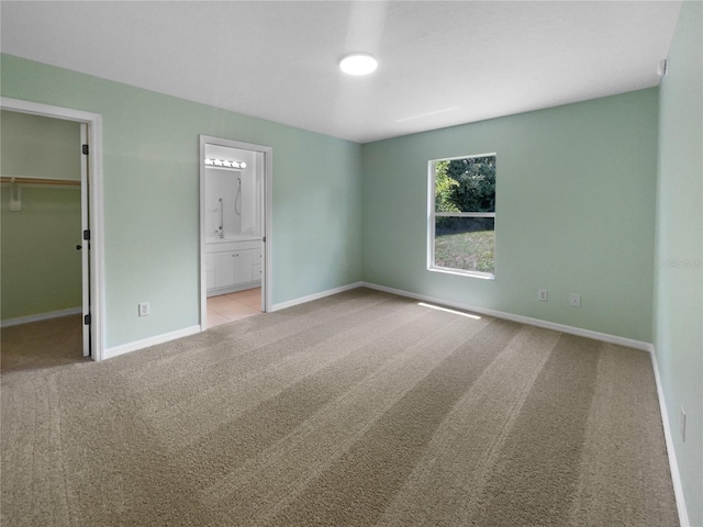 1877 Courtland Blvd, Deltona, FL 32738 - unfurnished bedroom with carpet flooring, a spacious closet, ensuite bathroom, and a closet