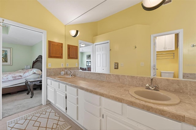 5704 Bay Side Dr, Orlando, FL 32819 - ensuite bathroom featuring vaulted ceiling, tile patterned flooring, and double vanity
