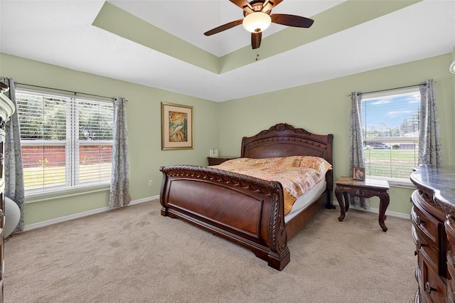 5704 Bay Side Dr, Orlando, FL 32819 - bedroom with a tray ceiling, light colored carpet, and a ceiling fan