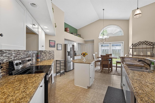 5704 Bay Side Dr, Orlando, FL 32819 - kitchen featuring appliances with stainless steel finishes, tasteful backsplash, light stone counters, white cabinets, and high vaulted ceiling