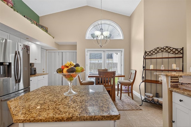 5704 Bay Side Dr, Orlando, FL 32819 - kitchen featuring stainless steel refrigerator with ice dispenser, high vaulted ceiling, a chandelier, white cabinetry, and light stone counters