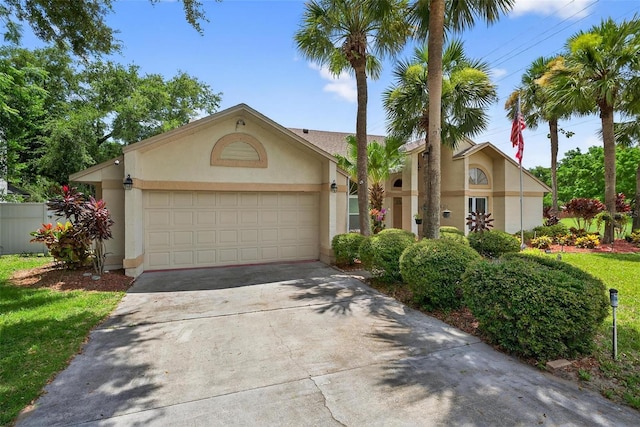 5704 Bay Side Dr, Orlando, FL 32819 - view of front of property with stucco siding, an attached garage, and driveway