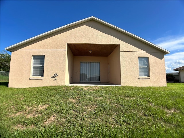 1433 Bluff Loop, Dundee, FL 33838 - rear view of house featuring stucco siding, a yard, and a patio