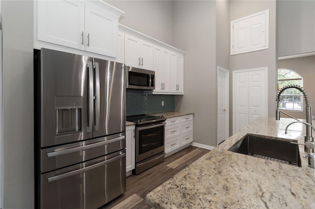 2865 Ashton Ter, Oviedo, FL 32765 - kitchen featuring stainless steel appliances, a high ceiling, tasteful backsplash, white cabinets, and dark wood-type flooring