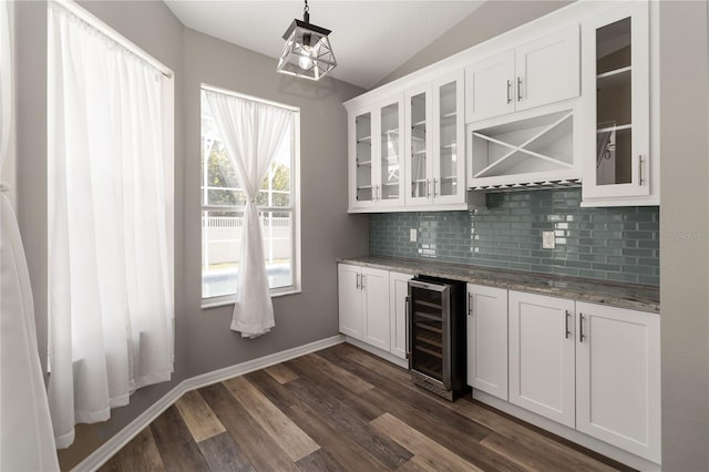 2865 Ashton Ter, Oviedo, FL 32765 - indoor dry bar featuring wine cooler, vaulted ceiling, decorative backsplash, dark wood-style floors, and decorative light fixtures
