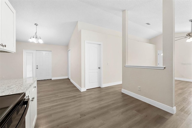 9558 Lupine Ave, Orlando, FL 32824 - kitchen featuring vaulted ceiling, stainless steel electric range, white cabinetry, a chandelier, and light wood-style flooring
