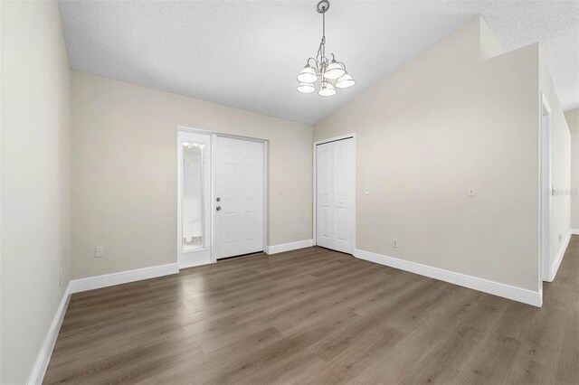 9558 Lupine Ave, Orlando, FL 32824 - unfurnished bedroom featuring a chandelier, wood finished floors, and lofted ceiling