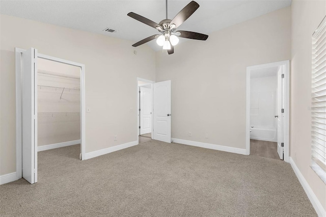 9558 Lupine Ave, Orlando, FL 32824 - unfurnished bedroom featuring carpet, a spacious closet, connected bathroom, a closet, and ceiling fan
