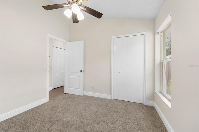 9558 Lupine Ave, Orlando, FL 32824 - unfurnished bedroom featuring carpet flooring, lofted ceiling, multiple windows, a closet, and ceiling fan