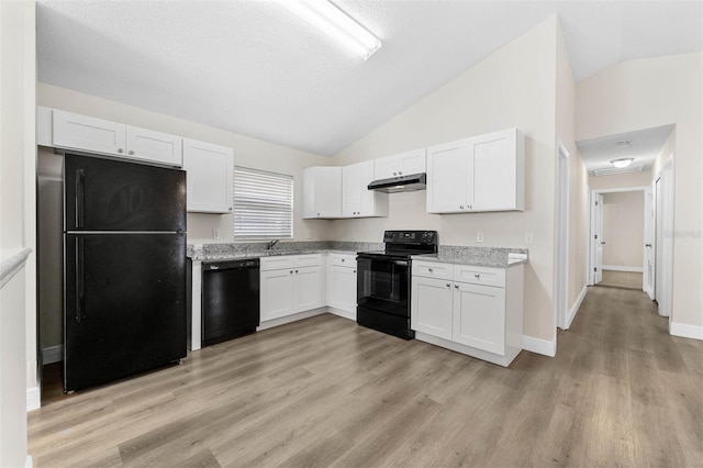 9558 Lupine Ave, Orlando, FL 32824 - kitchen featuring black appliances, under cabinet range hood, lofted ceiling, white cabinets, and light wood-style flooring