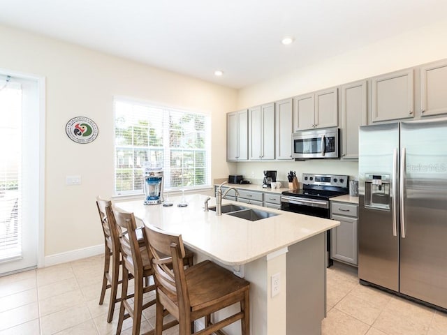 3004 Latitude Ln, Kissimmee, FL 34747 - kitchen with stainless steel appliances, gray cabinets, light tile patterned flooring, a breakfast bar area, and recessed lighting