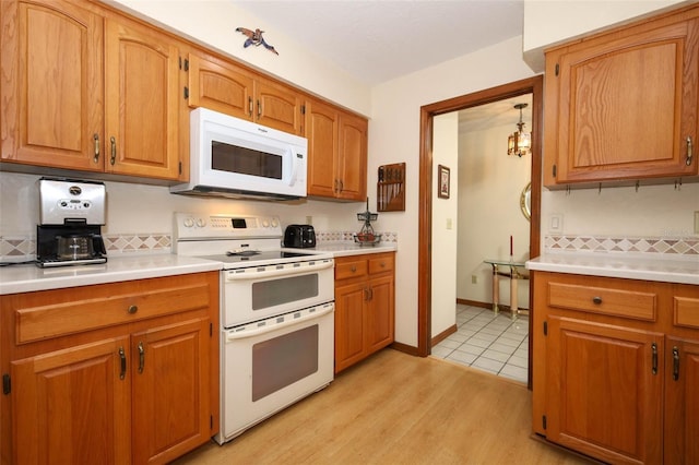 1121 Winged Foot Cir, Winter Springs, FL 32708 - kitchen with white appliances, light countertops, tasteful backsplash, and light wood-style floors