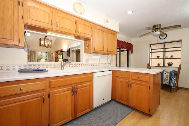 1121 Winged Foot Cir, Winter Springs, FL 32708 - kitchen featuring white dishwasher, tasteful backsplash, a peninsula, light countertops, and light wood-style flooring