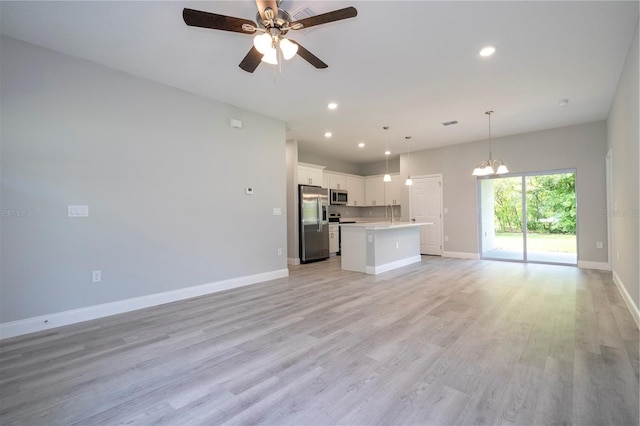 unfurnished living room featuring a chandelier, a ceiling fan, recessed lighting, and light wood-type flooring