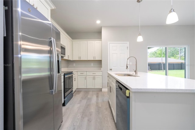 kitchen featuring stainless steel appliances, light wood-style flooring, white cabinetry, decorative light fixtures, and light stone counters