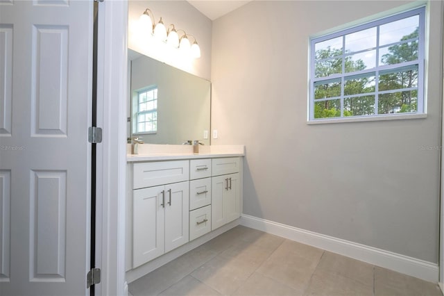 bathroom with double vanity and tile patterned flooring