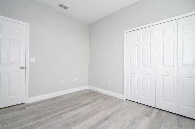 unfurnished bedroom featuring light wood-style floors and a closet