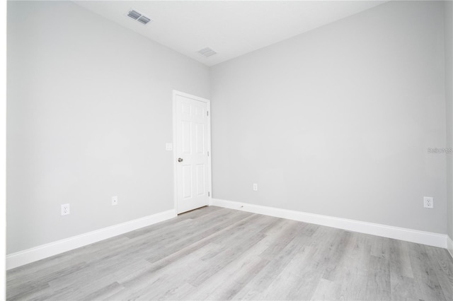 empty room featuring light wood-type flooring and baseboards