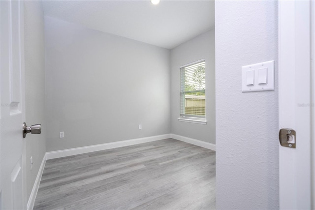 spare room with wood finished floors and baseboards