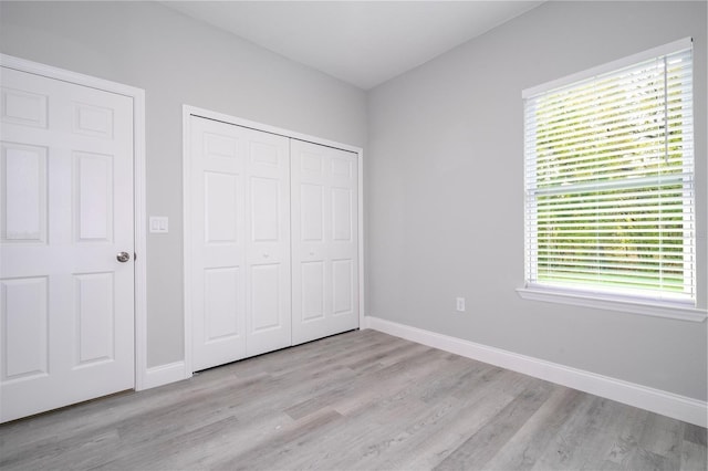 unfurnished bedroom featuring light wood-type flooring and a closet