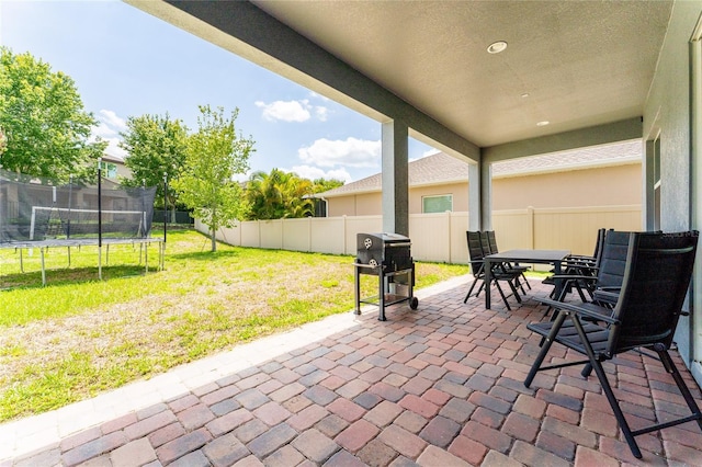 15716 Sweet Lemon Way, Winter Garden, FL 34787 - fenced backyard featuring a patio, a trampoline, outdoor dining space, and a grill