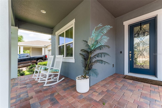 15716 Sweet Lemon Way, Winter Garden, FL 34787 - doorway to property featuring covered porch and stucco siding