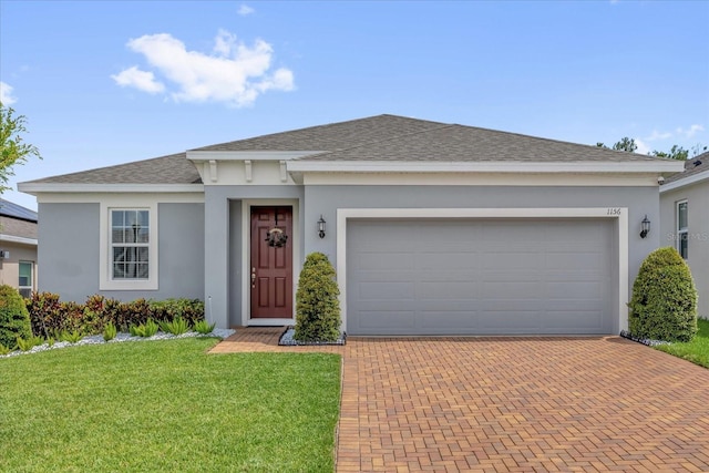 1156 Cavender Creek Rd, Minneola, FL 34715 - ranch-style house featuring a shingled roof, decorative driveway, stucco siding, a front yard, and an attached garage