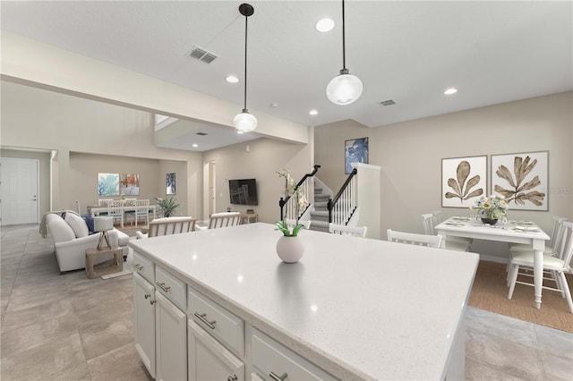 15019 Valverse Aly, Winter Garden, FL 34787 - kitchen with open floor plan, white cabinetry, recessed lighting, hanging light fixtures, and a kitchen island