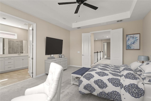15019 Valverse Aly, Winter Garden, FL 34787 - bedroom with light colored carpet, connected bathroom, a tray ceiling, and a ceiling fan