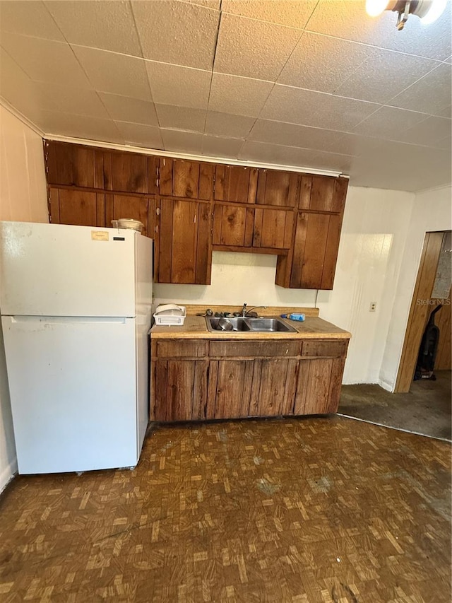 1425 26th St, Orlando, FL 32805 - kitchen with freestanding refrigerator, dark floors, light countertops, and brown cabinets