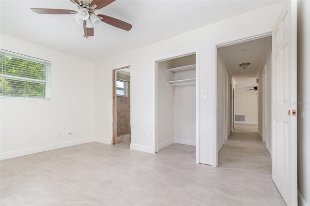 323 Scotland Dr, Daytona Beach, FL 32117 - unfurnished bedroom featuring multiple windows, ensuite bathroom, a closet, and ceiling fan