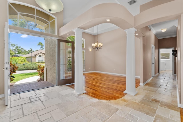 875 Bentley Green Cir, Winter Springs, FL 32708 - entrance foyer with decorative columns, stone tile flooring, a chandelier, arched walkways, and ornamental molding