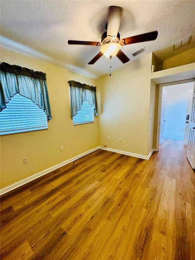 1115 Deer Creek Blvd, Davenport, FL 33837 - empty room featuring a textured ceiling, wood finished floors, and a ceiling fan