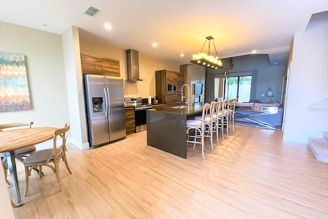 7478 Brooklyn Dr, Kissimmee, FL 34747 - kitchen with stainless steel appliances, wall chimney exhaust hood, modern cabinets, a breakfast bar area, and recessed lighting