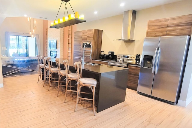 7478 Brooklyn Dr, Kissimmee, FL 34747 - kitchen featuring appliances with stainless steel finishes, wall chimney range hood, dark countertops, modern cabinets, and a breakfast bar