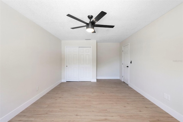 105 E Magnolia St, Davenport, FL 33837 - unfurnished bedroom with a textured ceiling, light wood-type flooring, a closet, and ceiling fan