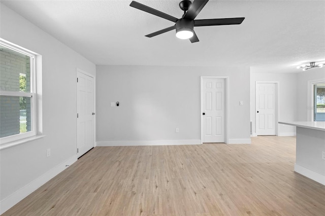 105 E Magnolia St, Davenport, FL 33837 - unfurnished living room featuring light wood finished floors, a ceiling fan, and a textured ceiling