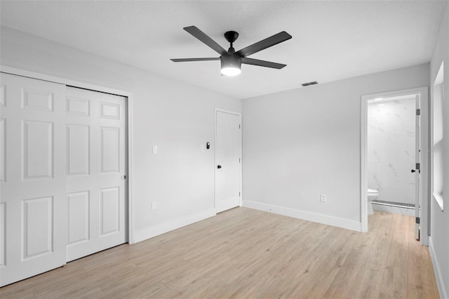 105 E Magnolia St, Davenport, FL 33837 - unfurnished bedroom featuring light wood-type flooring, ensuite bathroom, a closet, a ceiling fan, and a baseboard radiator