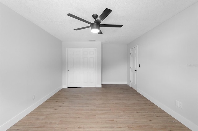 105 E Magnolia St, Davenport, FL 33837 - unfurnished bedroom featuring a textured ceiling, light wood-style floors, a closet, and ceiling fan