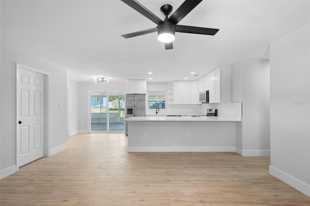 105 E Magnolia St, Davenport, FL 33837 - kitchen featuring stainless steel appliances, light countertops, ceiling fan, a peninsula, and white cabinets