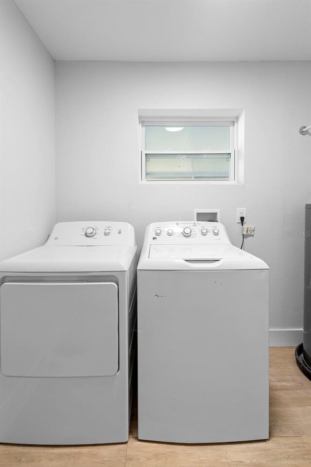 105 E Magnolia St, Davenport, FL 33837 - washroom with washer and dryer and light wood-style flooring