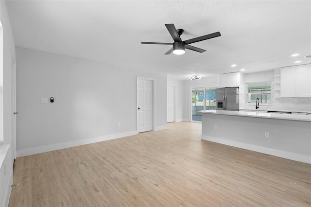 105 E Magnolia St, Davenport, FL 33837 - unfurnished living room with a ceiling fan, light wood finished floors, recessed lighting, and a textured ceiling