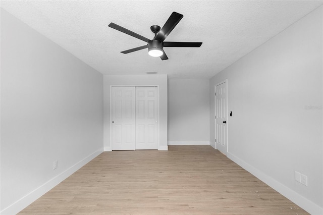 105 E Magnolia St, Davenport, FL 33837 - unfurnished bedroom featuring a textured ceiling, light wood-type flooring, a closet, and ceiling fan