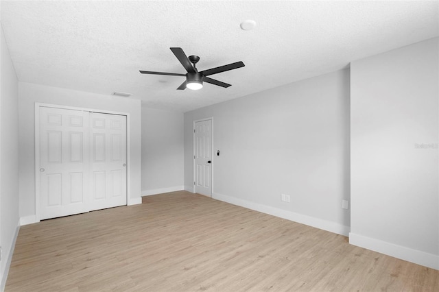 105 E Magnolia St, Davenport, FL 33837 - unfurnished bedroom with light wood-style flooring, a textured ceiling, a closet, and a ceiling fan