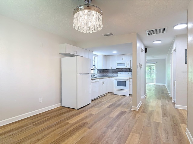 809 Sugar House Blvd, Port Orange, FL 32129 - kitchen with white appliances, light wood-style flooring, white cabinets, tasteful backsplash, and a chandelier