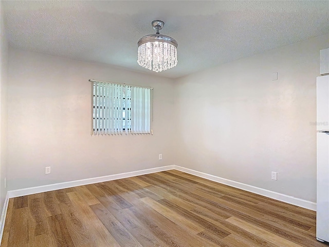 809 Sugar House Blvd, Port Orange, FL 32129 - spare room with a chandelier, wood finished floors, and a textured ceiling