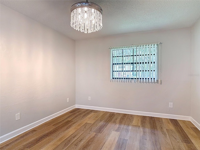 809 Sugar House Blvd, Port Orange, FL 32129 - spare room with a chandelier, wood finished floors, and a textured ceiling