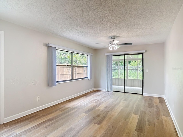 809 Sugar House Blvd, Port Orange, FL 32129 - spare room featuring light wood-type flooring, plenty of natural light, a textured ceiling, and a ceiling fan